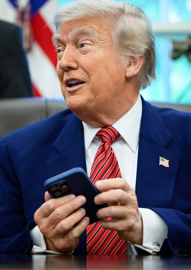 도널드 트럼프 미국 대통령이 23일(현지시간) 워싱턴 D.C 백악관에서 자신의 아이폰을 들고 있다. (사진=AFP)