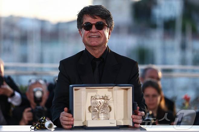 이란 반체제 영화감독 자파르 파나히가 24일(현지시간) 프랑스 칸에서 열린 제78회 칸 국제영화제서 영화 '잇 워스 저스트 언 액시던트'로 최고 작품상인 황금 종려상을 수상하고 있다. 2025.05.25 ⓒ 로이터=뉴스1 ⓒ News1 우동명 기자