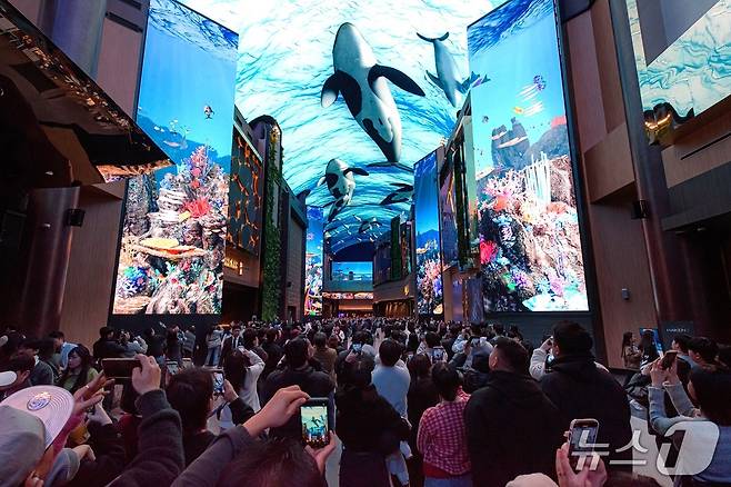 인스파이어의 랜드마크 중 하나인 몰입형 디지털 엔터테인먼트 거리 ‘오로라’의 화려한 미디어 쇼를 감상하기 위해 모인 관람객들(인스파이어 제공)
