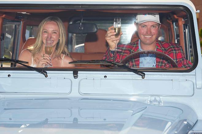 벤 그리핀(오른쪽)이 26일 미국 텍사스주 콜로니얼 컨트리클럽에서 PGA 투어 찰스 슈와브 챌린지 우승을 차지한 뒤 부상으로 받은 차량에 탑승해 약혼녀와 함께 샴페인을 마시며 자축하고 있다./AFP 연합뉴스