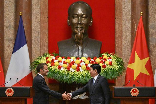 에마뉘엘 마크롱(왼쪽) 프랑스 대통령과 르엉 끄엉 베트남 국가주석이 26일 하노이 주석궁에서 만나 악수를 나누고 있다. 하노이=EPA 연합뉴스