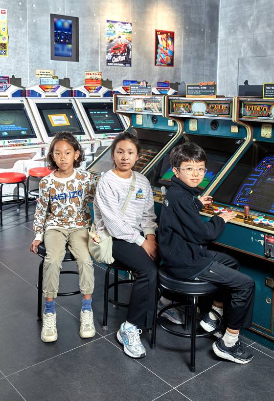 이성빈·정서우·최수혁(왼쪽부터) 학생기자가 오락실 느낌이 나도록 꾸민 ‘플레이컬렉션’에서 '보글보글' '올림픽' 등 1980~90년대 유행한 게임을 체험했다.