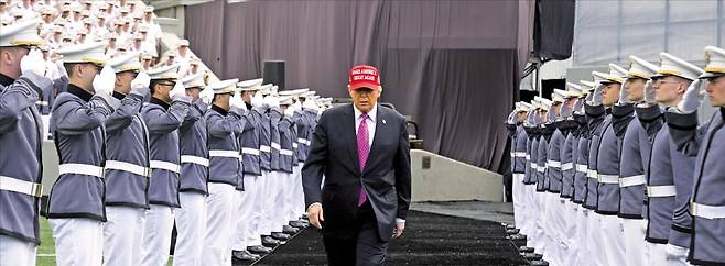 < 美육사 졸업식 참석한 트럼프 > 도널드 트럼프 미국 대통령이 24일(현지시간) 뉴욕 웨스트포인트에 있는 미 육군사관학교에서 졸업식 축사를 하기 위해 이동하고 있다. 트럼프 대통령은 연설에서 “미국과 동맹이 공격받으면 군은 압도적이고 파괴적인 무력으로 적들을 없앨 것”이라고 경고했다.   AFP연합뉴스