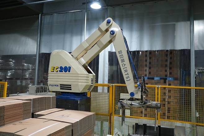 지난 21일 태림포장 시화공장 내에 있는 로봇 시스템이 20매씩 묶인 골판지 박스를 자동으로 파렛트에 적재하고 있다. 태림포장 제공