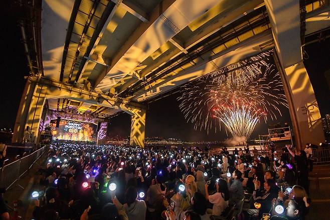 Fans cheer for Seventeen on Jamsu Bridge in Seoul, Sunday, as the group performs  its 10th anniversary concert "B-Day Party: Burst Stage." (Pledis Entertainment)