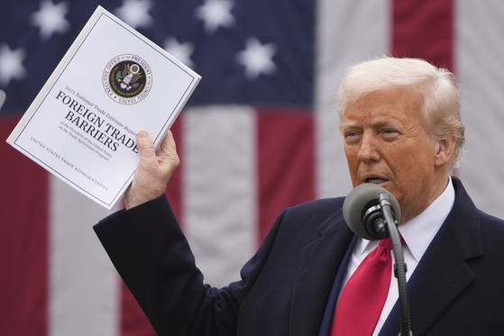 U.S. President Donald Trump holds the 2025 National Trade Estimate Report on Foreign Trade Barriers by the Office of the United States Trade Representative during an event to announce new tariffs at the White House on April 2 in Washington. [AP/YONHAP]