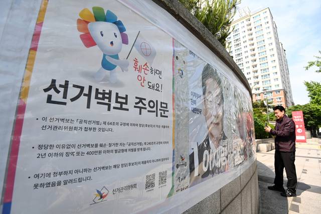 26일 오전 서울 시내 거리에 붙은 ‘선거 벽보를 훼손하면 처벌을 받는다’는 내용의 선거관리위원회 주의문.   문호남 기자