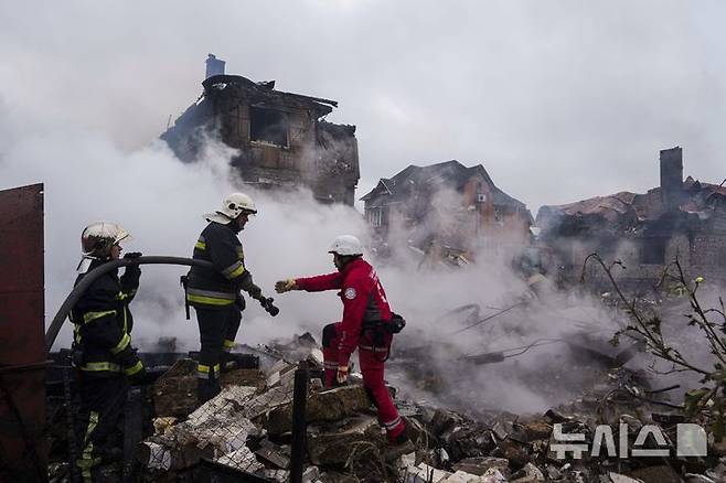 [키이우=AP/뉴시스]25일(현지 시간) 우크라이나 키이우 마르할리우카에서 구조대원들이 러시아의 공습으로 파괴된 주택에서 발생한 화재를 진압하고 있다. 2025.05.26.