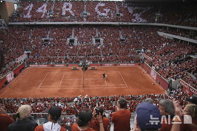 [파리=AP/뉴시스] 25일(현지 시간) 프랑스 파리 롤랑가로스의 메인 코트 필리프 샤트리에 센터 코트에서 라파엘 나달의 은퇴식이 열려 팬들이 나달에게 경의를 표하고 있다. 나달은 클레이코트인 프랑스오픈에서 14회 우승하며 '흙신'으로 불렸다. 2025.05.26.