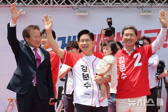 [안성=뉴시스] 권창회 기자 = 김문수 국민의힘 대선 후보가 26일 경기 안성시 안성중앙시장 인근에서 열린 유세에서 아이와 함꼐 기념촬영을 하고 있다. (공동취재) 2025.05.26. photo@newsis.com