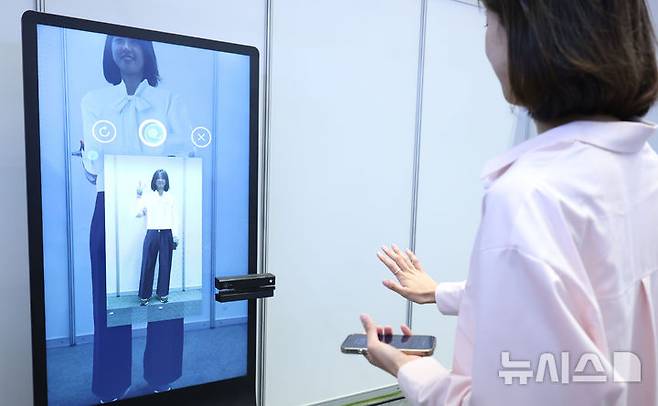 [서울=뉴시스] 조수정 기자 = 26일 서울 강남구 코엑스에서 열린 2025 제1차 KB굿잡 우수기업 취업박람회에서 취업준비생이 AI 의상 추천을 받고 있다. 2025.05.26. chocrystal@newsis.com