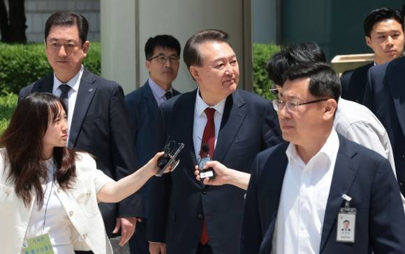 윤석열 전 대통령이 26일 서울 서초구 서울중앙지방법원에서 열린 내란 우두머리 혐의ㆍ직권남용 권리행사 방해 혐의 사건 5차 오전 공판을 마친 뒤 지지자들을 바라보며 차량으로 향하고 있다. 2025.5.26 사진공동취재단