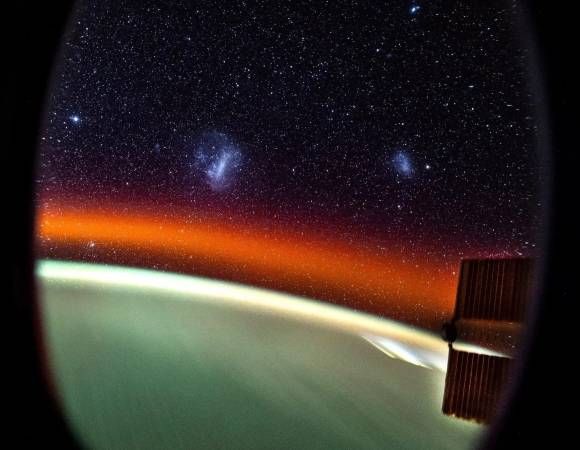 우주비행사 돈 페티트가 촬영한 지구와 마젤란은하. 붉은빛의 정체는 대기광(大氣光)이며 우주 저 멀리 흰색으로 뭉쳐진 두 개의 천체는 각각 대마젤란은하(사진 왼쪽)와 소마젤란은하(오른쪽)다.  NASA/Don Pettit