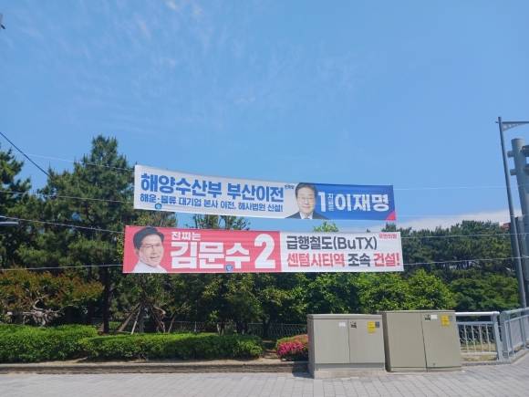 26일 부산 해운대구의 한 거리에 양당의 대선 후보가 제시한 공약들이 담긴 현수막이 걸려있다. 이재명 더불어민주당 후보는 해양수산부의 부산 이전을 공약했고, 김문수 국민의힘 후보는 부산형 급행철도(BuTX)의 센텀시티역 조속 건설을 약속했다. 부산 김서호 기자