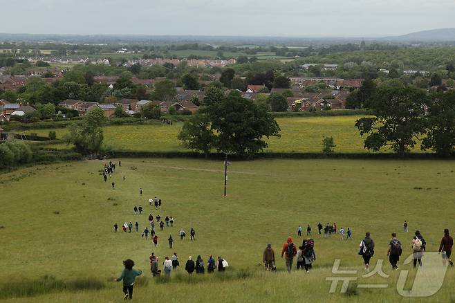 26일(현지시간) 영국 브록웍스의 쿠퍼스 힐에서 열린 '구르는 치즈 잡기' 대회에서 참가자들이 치즈를 쫒아 언덕을 내려가고 있다.  ⓒ 로이터=뉴스1