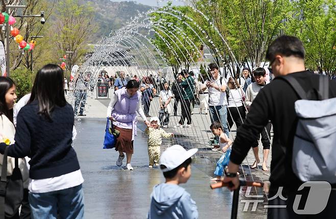 서울 광화문광장에서 시민과 관광객들이 분수터널을 지나고 있다. /뉴스1 ⓒ News1 허경 기자