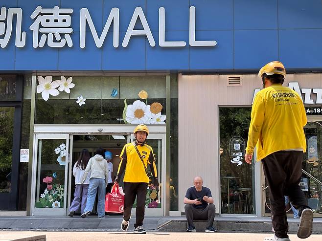 27일 오후 12시쯤 중국 베이징의 쇼핑몰 앞에 노란색 유니폼을 입은 메이퇀 배달원들이 오가는 모습. 이 무렵 인근 거리에 다니는 오토바이의 절반가량은 배달원이었다. /베이징=이은영 특파원