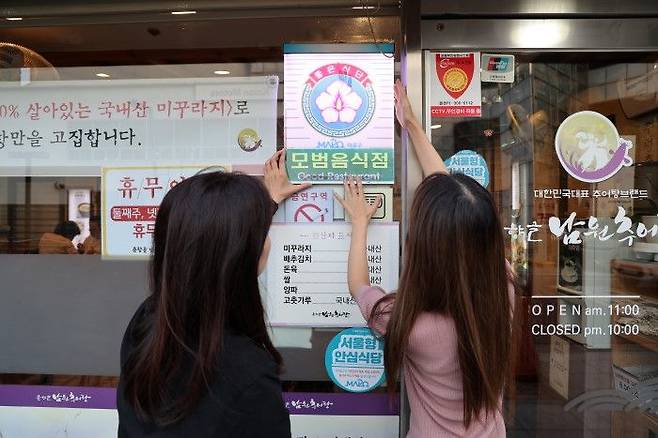 모범음식점으로 선정된 음식점에 모범음식점 표지판을 다는 모습ⓒ마포구 제공