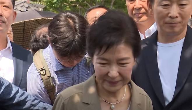 추모관 앞에서 지지자들과 취재진 사이에 선 박 전 대통령이 질문을 받고 있다. ⓒSBS 캡처