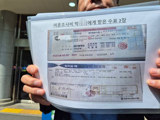 김영선 전 국회의원의 측근이 26일 오전 경남 창원지법 법정동 앞에서 '홍준표 전 대구시장 측근인 박모씨가 미래한국연구소 쪽에 준 수표 2장'라며 해당 수표 1장과 수표 출금표 1장을 공개하고 있다. 안대훈 기자