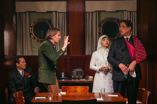 영화 <페니키안 스킴>의 촬영 현장 스틸컷. 녹색 옷을 입은 웨스 앤더슨 감독이 배우들에게 지시를 하고있다. 유니버셜 픽처스 제공