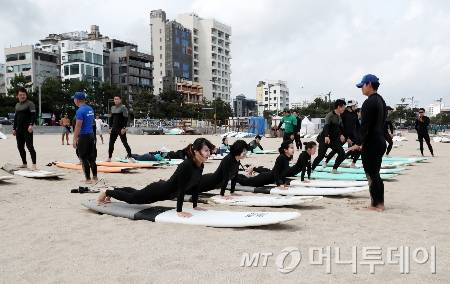 부산 해운대구 송정해수욕장에서 체육 담당 교사들이 부산시서핑협회 소속 강사에게 서핑 기본 자세 등을 배우고 있다. 사진은 기사와 직접적인 관련이 없음./사진=(부산=뉴스1) 윤일지 기자