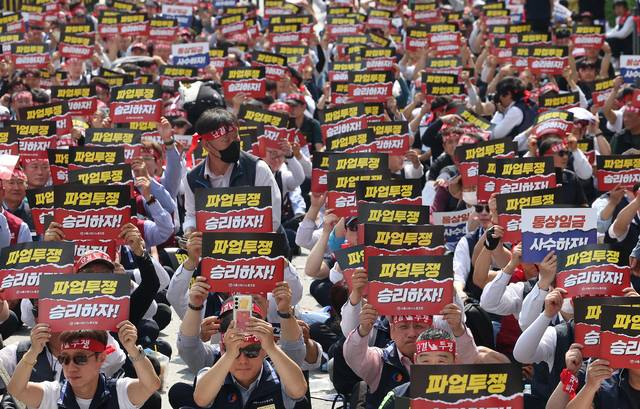 전국자동차노련 서울시버스노조가 26일 서울 송파구 서울시교통회관 앞에서 연 파업 출정식에서 조합원들이 손팻말을 들고 있다. 자동차노련 산하 버스 노조는 임금·단체협약(임단협) 교섭이 결렬될 경우 오는 28일 첫 차부터 전국 동시 파업에 들어간다고 예고했다.  연합뉴스