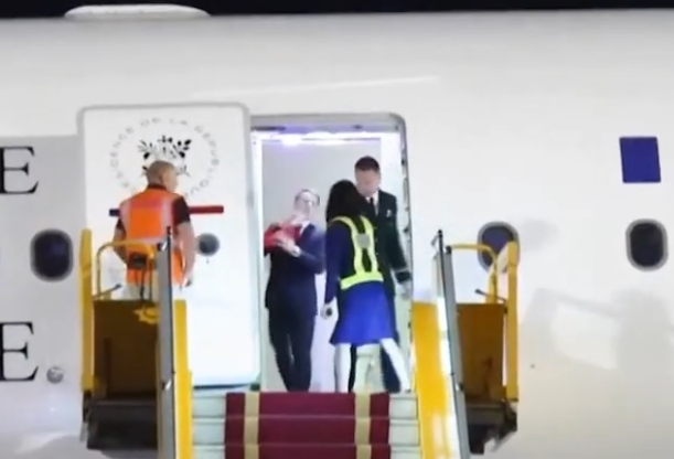 에마뉘엘 마크롱 프랑스 대통령이 베트남 하노이에 도착한 전용기 안에서 아내의 팔에 얼굴이 밀쳐지고 있다. [CNBC 캡처]