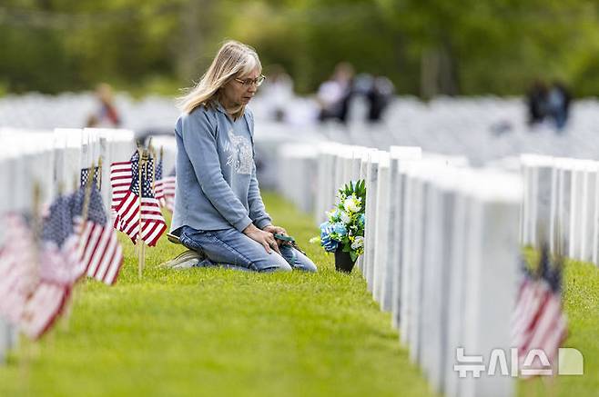 <font style="vertical-align: inherit;"><font style="vertical-align: inherit;">[홀리 타운십=AP/뉴시스] 지난 25일(현지 시간) 미 미시간주 홀리 타운십에 있는 그레이트 레이크스 국립묘지에서 한 여성이 메모리얼 데이(현충일) 추념식 후, 묘역을 참배하고 있다. 2025.05.27.</font></font>