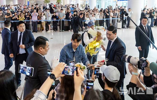 [인천공항=뉴시스] 김선웅 기자 = 유로파리그에서 우승한 토트넘의 손흥민이 27일 인천국제공항을 통해 귀국하며 팬에게 꽃다발을 전달받고 있다. 2025.05.27. mangusta@newsis.com