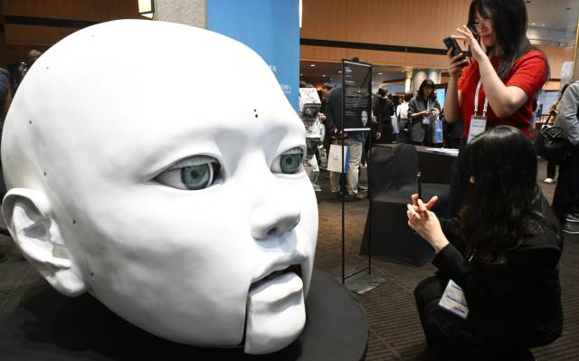 27일 서울 중구 신라호텔에서 열린 서울포럼 2025에서 참석자들이 행사장 입구에 전시된 노진아 작가의 AI 기반 인터랙티브 조각상 '히페리온의 속도' 작품을 카메라에 담으며 말을 걸고 있다. /오승현기자