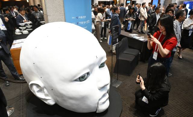 ‘서울포럼 2025’ 참석자들이 행사장 입구에 전시된 노진아 작가의 AI 기반 인터랙티브 조각상 '히페리온의 속도' 작품을 카메라에 담으며 말을 걸고 있다. 오승현 기자