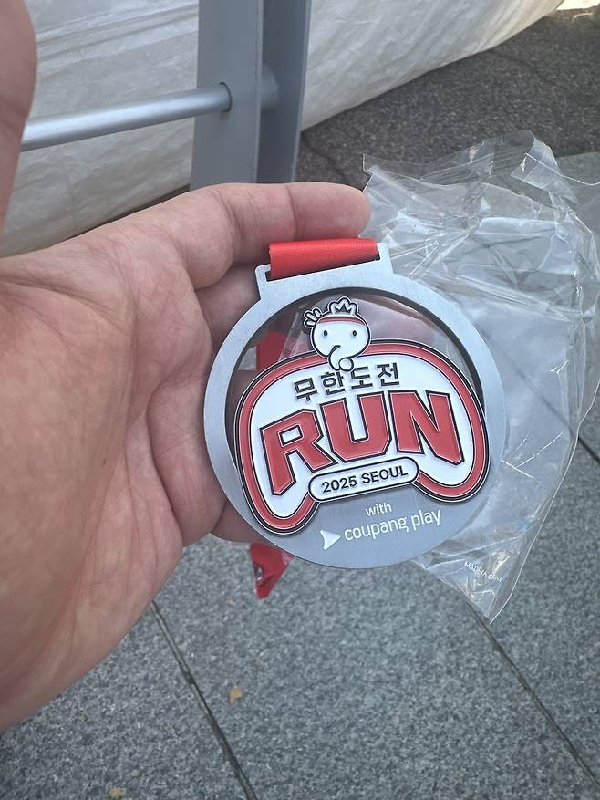 지난 25일 서울 여의도공원에서 열린 ‘무한도전 RUN with 쿠팡플레이’에서 기자가 수령한 완주 메달. 사진 하경헌 기자