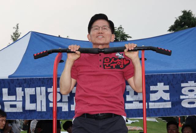 김문수 국민의힘 대선 후보가 28일 경북 경산시 영남대학교를 방문해 축제 현장에서 턱걸이를 하고 있다. 연합뉴스.