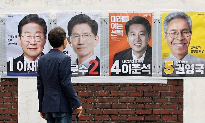 21대 대통령선거를 앞두고, 지난 15일 오후 시민이 광주 동구 전남여자고등학교 담벼락에 붙은 선거 벽보를 바라보고 있다. 김영원 기자 forever@hani.co.kr