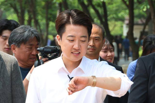 사전투표를 하루 앞둔 28일 '반명(反이재명) 후보 단일화'가 사실상 불발 수순으로 가는 가운데 개혁신당 이준석 후보가 서울 여의도공원에서 직장인 유권자들에게 인사를 하던 중 시계를 보고 있다. 연합뉴스