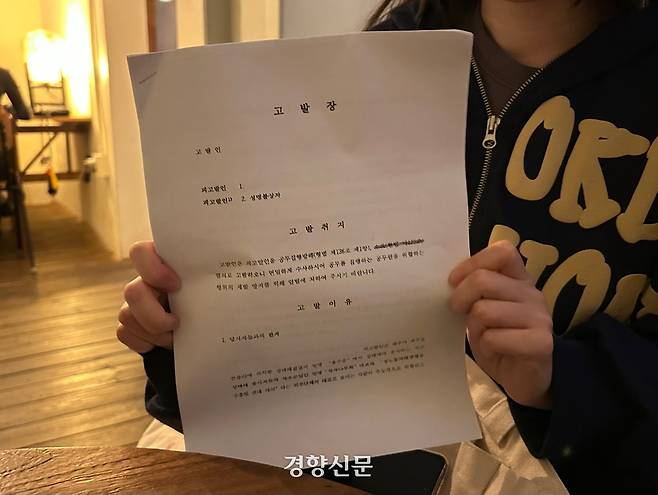 지난 25일 성노동자해방행동 주홍빛연대 차차 활동가 여름(활동명)이 파주시장 명의로 작성된 고발장을 들고 있다. 최혜린 기자