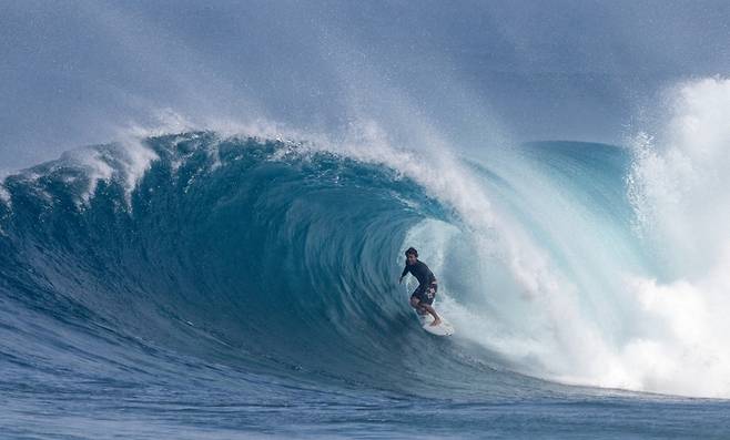 2월18일(현지시간) 하와이 오아후섬 북쪽 해안에서 프로 서퍼가 파도를 타고 있다./AFPBBNews=뉴스1