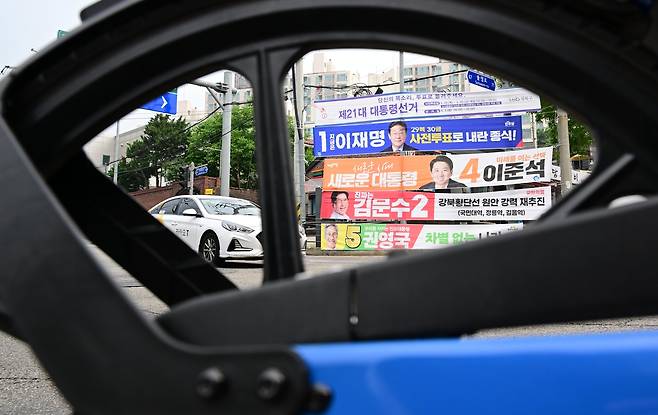 제21대 대통령 선거 사전투표를 하루 앞둔 28일 오전 서울 성북구 정릉 인근에 이재명(위쪽부터) 더불어민주당, 김문수 국민의힘, 이준석 개혁신당, 권영국 민주노동당 대선후보의 현수막이 걸려 있다. 이상섭 기자