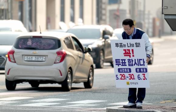 김영록 전남지사가 28일 순천 에코그라드호텔 사거리에서 출근길 시민들을 향해 투표 참여 독려 1인 캠페인을 하고 있다