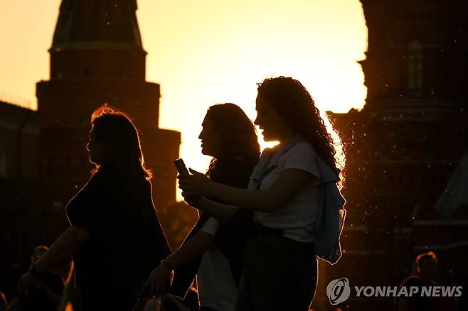 휴대전화 보면서 러시아 모스크바 붉은광장 걷는 사람들 [타스 연합뉴스 자료사진. 재판매 및 DB 금지]