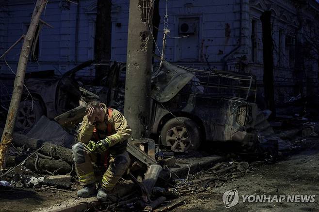 러시아의 미사일 공격으로 파괴된 수미주의 한 대학 건물 옆에 주저앉은 현지 구조대원의 모습 [AP 연합뉴스 자료사진. 재판매 및 DB 금지]