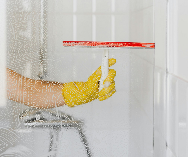 샤워 부스를 닦는 모습