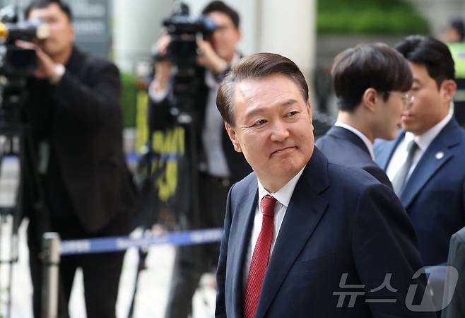 윤석열 전 대통령이 26일 오후 서울 서초구 중앙지방법원에서 열린 내란 우두머리 혐의, 직권남용 권리행사방해 혐의 사건 5차 공판을 마친 후 법원을 나서며 지지자들을 보고 있다. 2025.5.26/뉴 스1 2025.5.26/뉴스1 ⓒ News1 사진공동취재단