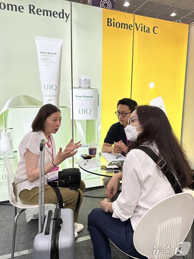 지놈앤컴퍼니 유이크 관계자가 2025 코스모뷰티에 참가한 바이어 등에게 브랜드 소개를 하고 있다.(지놈앤컴퍼니 제공)/뉴스1