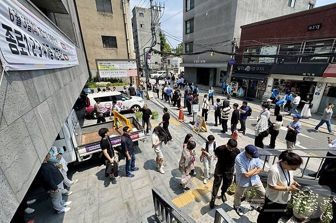 제21대 대통령선거 사전투표 첫 날인 29일 서울 종로구 종로1·2·3·4가동 주민센터 투표소에 마련된 투표소에서 직장인들이 점심시간을 이용해 투표를 위해 길게 줄을 늘어서 있다. 2025.5.29/뉴스1 ⓒ News1 유승관 기자