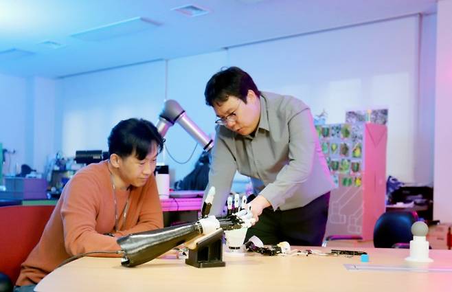 신민기 한국기계연구원 대구융합기술연구센터 의료로봇연구실 선임연구원(오른쪽)과 안보현 선임기술원이 개발한 로봇 의수를 살펴보고 있다. 기계연 제공.
