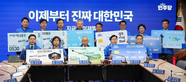 윤여준, 박찬대 더불어민주당 상임총괄선거대책위원장을 비롯한 선대위원장들이 21일 서울 여의도 더불어민주당 당사에서 열린 중앙선거대책위원회의 시작에 앞서 지역화폐 사용을 촉구하는 퍼포먼스를 하고 있다.뉴시스