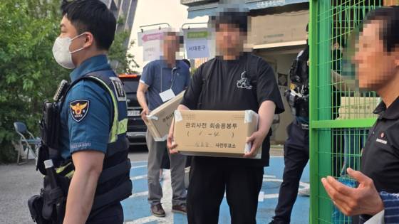 29일 오후 6시 48분쯤 선거 참관인 등이 투표용지를 들고 밖으로 나오고 있다. 김창용 기자