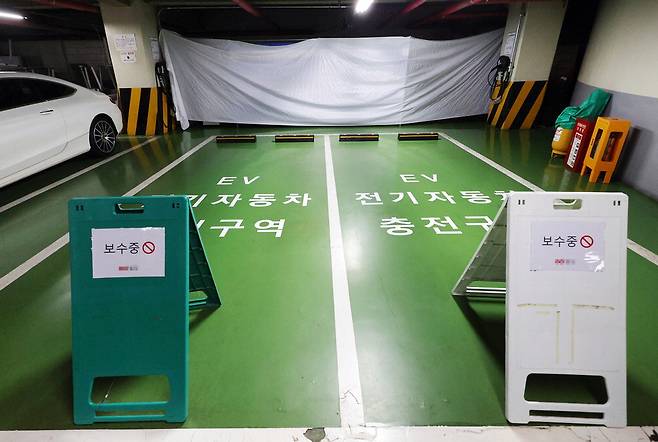 충전사업자 폐업에 … 방치된 주차장 29일 서울 중구의 한 빌딩 지하 주차장에 위치한 전기차 충전구역에 '보수 중'이라는 입간판이 서 있다. 이곳을 운영하던 전기차 충전사업자는 폐업 절차에 돌입했는데, 건물주 측은 전기차 출입 통제 조치까지 추가했다. 이충우 기자